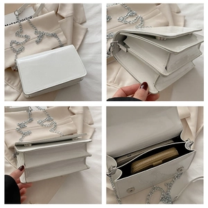 Internal view showing two compartments of a white patent leather bag with a silver chain