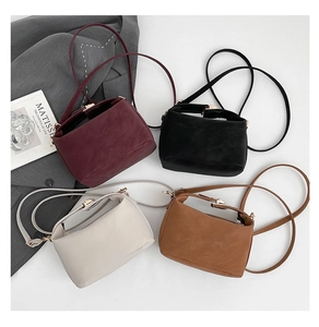 Flat lay of four minimalist crossbody bags in wine red, black, beige, and brown colors