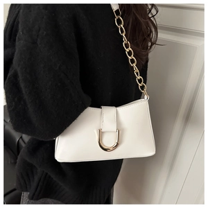 Gros plan du sac à bandoulière blanc avec chaîne dorée et boucle métallique en U