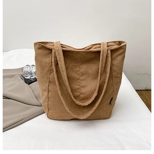Close-up of brown corduroy tote bag featuring ribbed texture and large front pocket