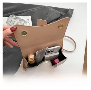 Detail view of the spacious inner compartment of the beige faux leather crossbody bag