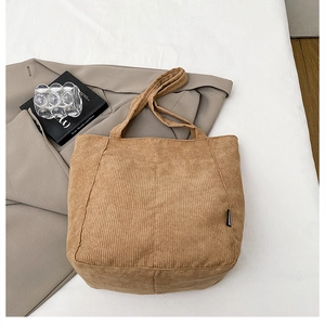 Detail of vintage corduroy tote bag featuring a textured vertical stripe and fashion label