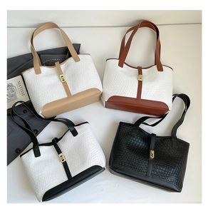 Detailed overhead view of contrast-color textured tote bags with golden metal locks