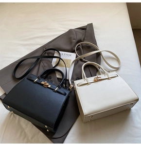 Close-up of leather texture and gold metal turn-lock closure on Kelly style bags