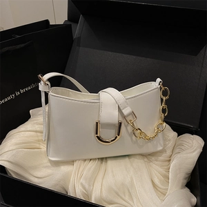 Sac sous les aisselles en cuir blanc avec boucle D dorée et chaîne sur fond élégant