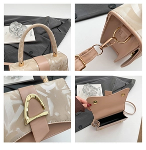Détails du sac bandoulière beige avec boucle dorée en D et finition texturée