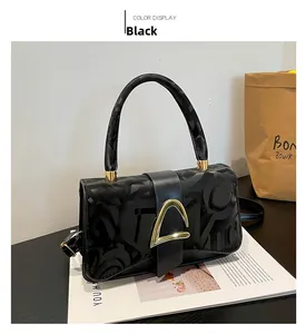 Détail du sac carré en cuir noir avec texture monogramme et boucle en métal doré