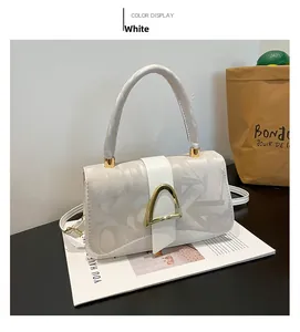 Sac bandoulière blanc avec motifs de lettres grises et fermoir triangle doré