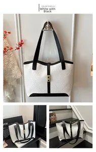 Detail of the black and white woven tote bag featuring a leather strap and golden clasp