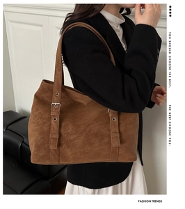 Detail of adjustable silver buckle and vintage textured brown faux leather tote bag