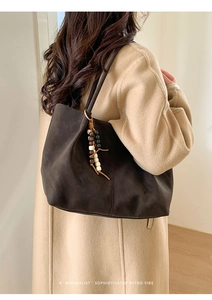Dettaglio borsa tote minimalista in pelle scamosciata marrone con pendente di perline