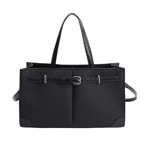 Minimalist black tote bag with textured fabric and elegant silver buckle leather strap