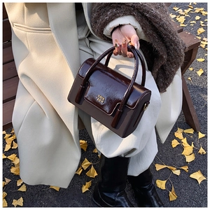 Detail of vintage tote bag with gold lettering on a stylish brown patchwork flap
