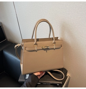 Close-up of khaki Saffiano leather texture and elegant gold twist lock on Kelly handbag