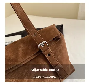 Detail of adjustable silver buckle and vintage brown textured leather on shoulder bag