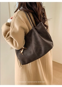 Dettaglio della borsa tote retrò marrone scuro con ciondolo di perline e texture scamosciata