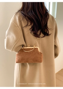 Dettaglio di una borsa retrò in pelle scamosciata marrone con manico e catena d'oro