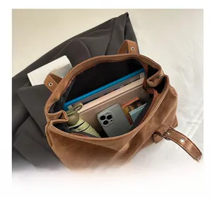 Macro view of the brown suede tote bag showing its large interior capacity and zipper