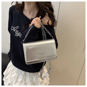 Silver metallic crossbody bag with chain strap shown on model for a stylish casual look