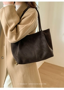 Borsa tote minimalista marrone scuro stile retrò indossata da una modella con luce naturale
