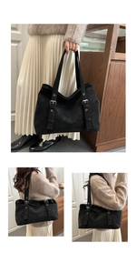 Macro detail of black matte leather tote bag with silver buckles and decorative eyelets