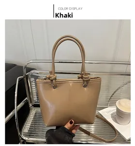Detail of khaki bucket bag showing knotted handles and detachable shoulder strap