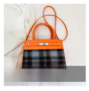 Detailed size comparison of the orange leather and plaid crossbody bag with phone