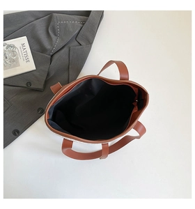 Detailed top view showing the wide opening and interior lining of the brown tote bag