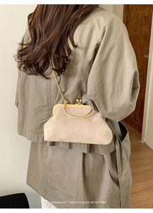 Dettaglio borsa a tracolla vintage beige con motivo rich rabbit e catena dorata sottile