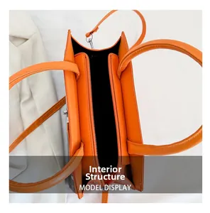 Interior view of orange tote bag showing multiple compartments and metal zipper pockets