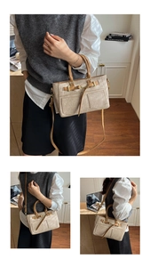 Detail view of beige leather bag featuring dual top handles and gold-tone buckle accents
