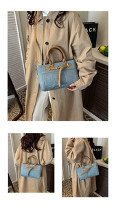 Detail of blue denim and brown leather handbag showing metal buckle and stitching