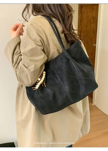 Dettaglio borsa tote nera retrò con ciondolo di perline e finitura opaca elegante
