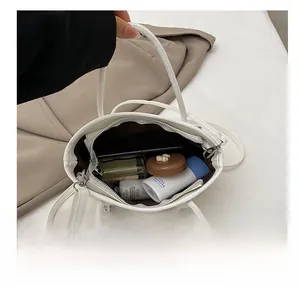 Vue de dessus du sac bandoulière blanc montrant sa grande capacité et ses accessoires