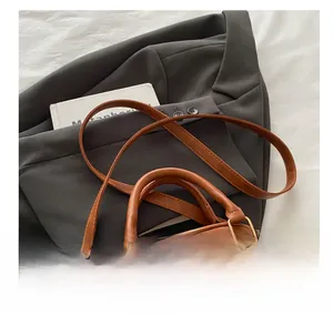Detail of vintage brown leather bag strap attached with premium gold metal rings