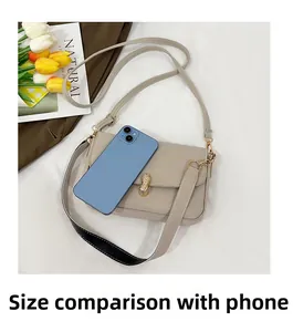 Size comparison of a beige leather crossbody bag with peanut-shaped gold lock and phone