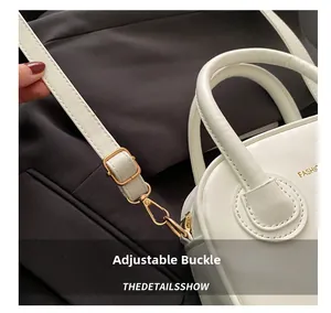 Détail de la boucle dorée ajustable et de la bandoulière en cuir blanc du sac à main
