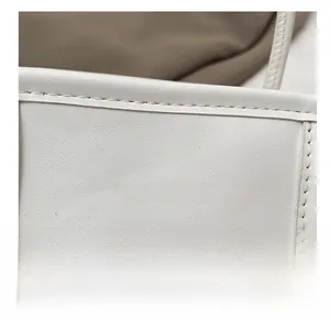 Détail macro du sac en cuir blanc crème avec logo FASHION embossé et coutures précises