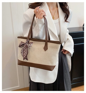 Minimalist canvas tote bag with leather trim and decorative patterned silk scarf detail
