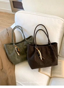 Detail of retro suede tote bags in dark green and brown with beaded tassels