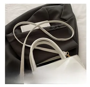 Détails d'un sac blanc avec nœud décoratif et bandoulière en chaîne dorée chic