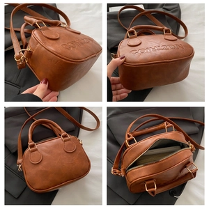 Close-up of vintage brown PU leather bag showing embossed logo and golden hardware