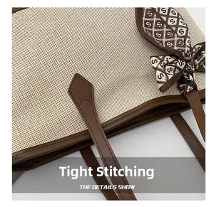 Detail view of large tote bag with precise stitching and silk scarf accent on handle