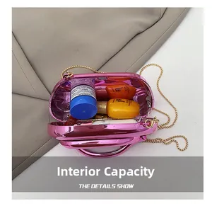 Détail de l'intérieur d'une pochette rose brillante montrant la capacité et la chaîne