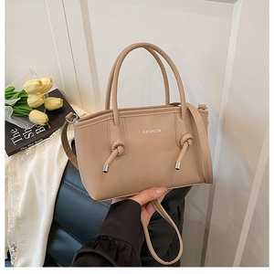 Détail du petit sac carré beige avec nœuds décoratifs et fine bandoulière amovible