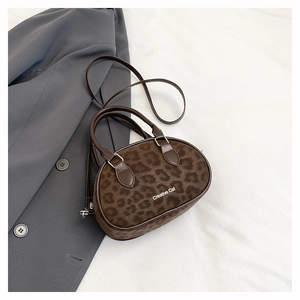 Detail of leopard print oval crossbody bag with velvet texture and Creative Cat text