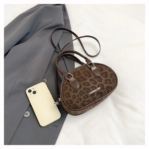 Detail of leopard print round handbag with Creative Cat text on plush brown suede texture