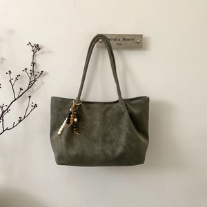 Olive green tote bag with vintage faux leather texture and decorative beaded tassel charm