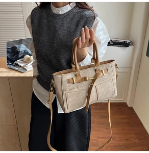 Detail of beige and brown crossbody bag with utility pockets and gold hardware accent