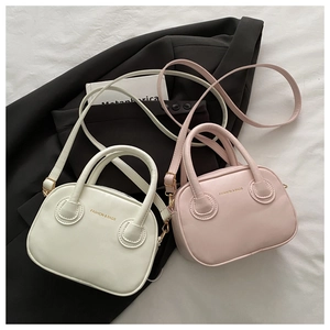 Detailed shot of cream and pink mini PU leather tote bags with detachable straps